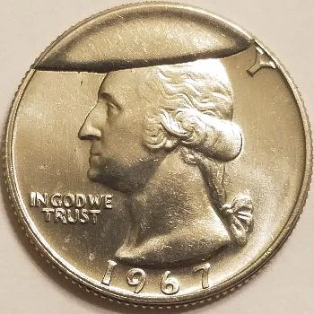 Large full cud error on a coin showing a blank raised area where the die broke away