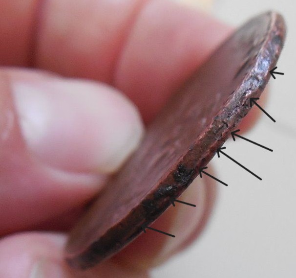 Close-up of a counterfeit coin showing edge seam diagnostic
