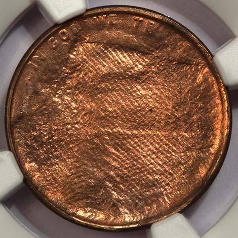 Lincoln cent struck through cloth — the weave pattern of the fabric is clearly visible across the entire obverse